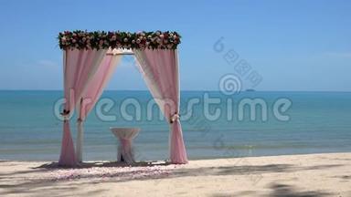 海边沙滩上的粉色婚礼拱门